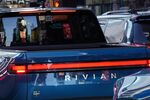 Billboards in Times Square are reflected in the rear window of a Rivian R1T electric pickup truck during the company's IPO outside the Nasdaq MarketSite in New York, U.S.,