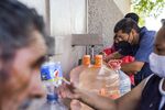 Residents line up to fill plastic bottles from a tap near central Monterrey. Since June, officials have&nbsp;limited city residents’ water access to&nbsp;seven&nbsp;hours a day.