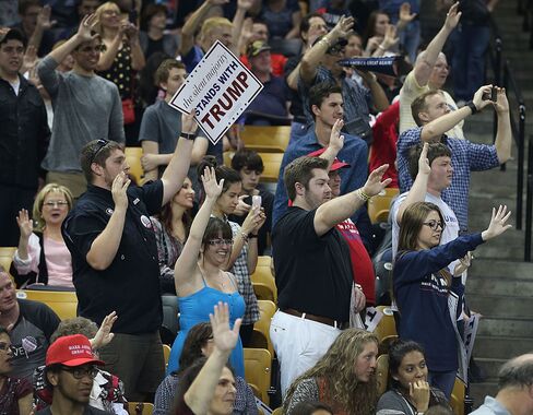 People raise their arms as Republican presidential candidate Donald Trump asks them to pledge that they will vote for him during a campaign rally on March 5, 2016, in Orlando, Florida.