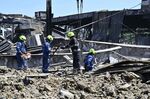 Workers clear the rubble at a Ukrainian shopping center hit by a Russian missile strike.