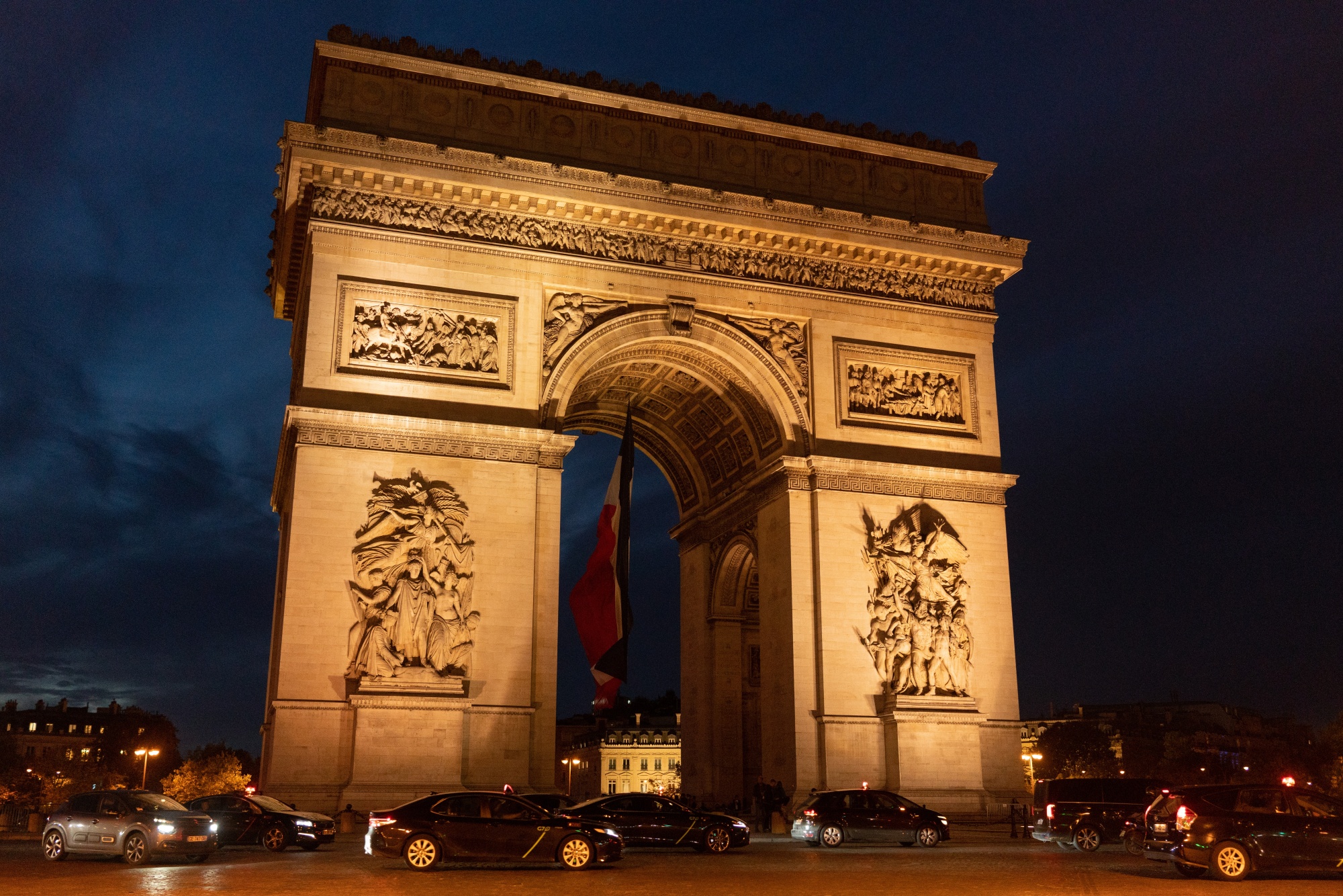 The Arc de Triomphe lit at night in Paris, France. 