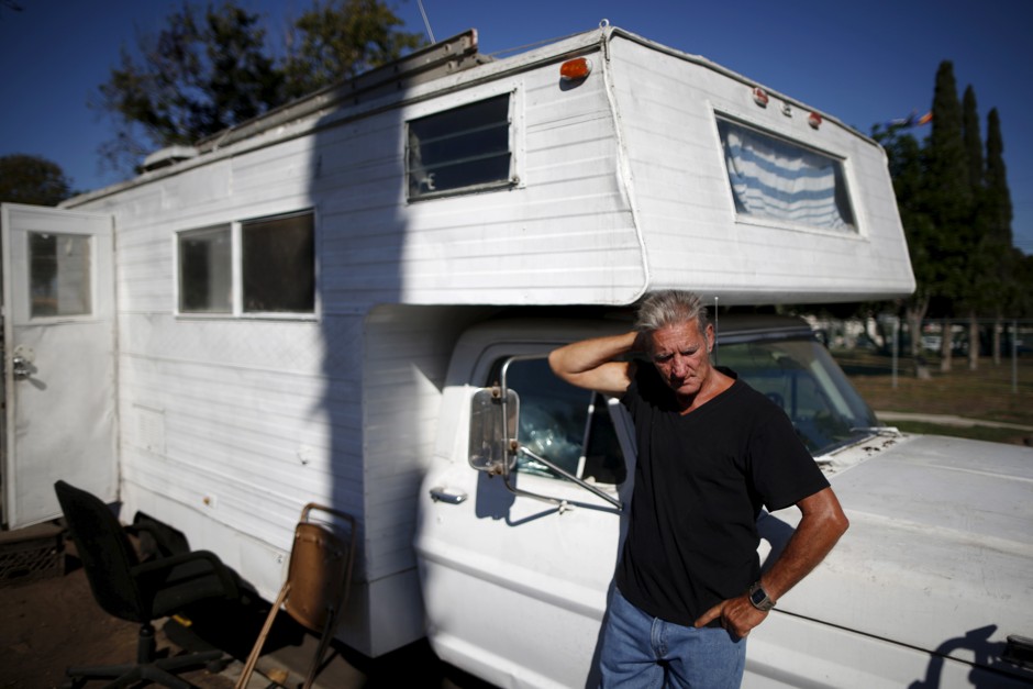 Nathan Allen, 65, poses for a portrait in front of the motorhome where he sleeps in an encampment near LAX airport in Los Angeles.