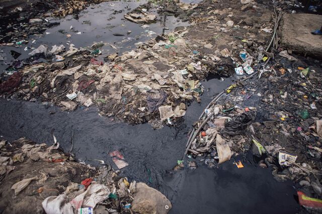 Ink-black wastewater mixes with discarded trash in Mukuru.