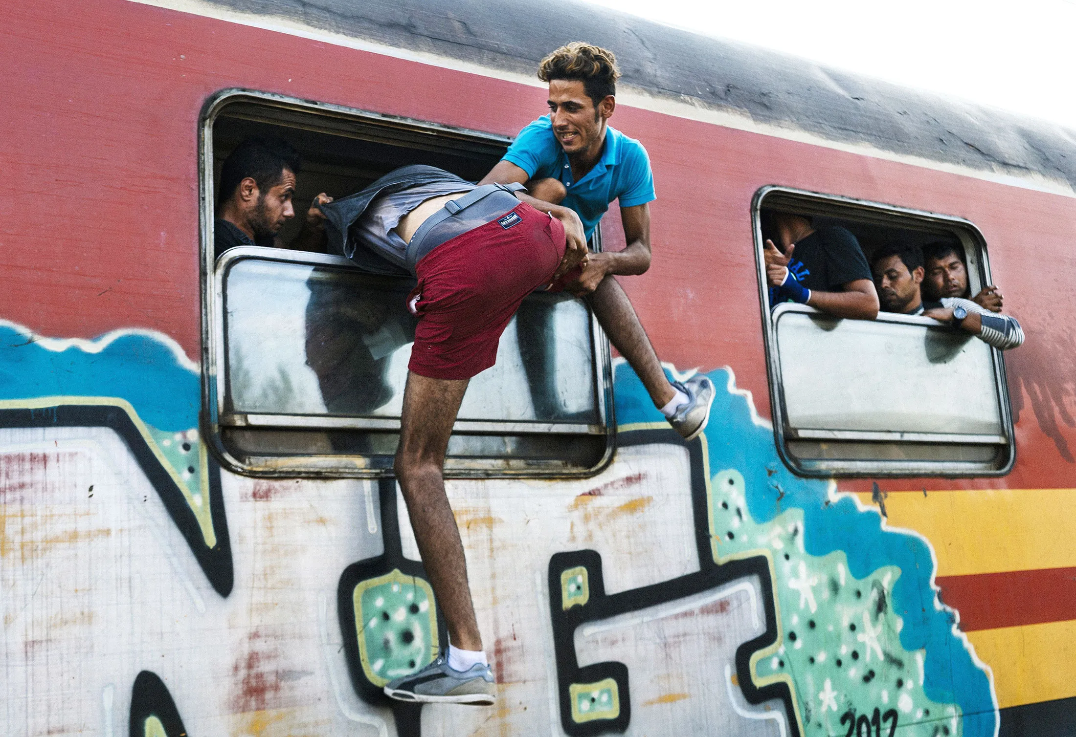 A migrant tries to climb into a train heading to the border with Serbia at the train station of Gevgelija, on the Macedonian-Greek border.
