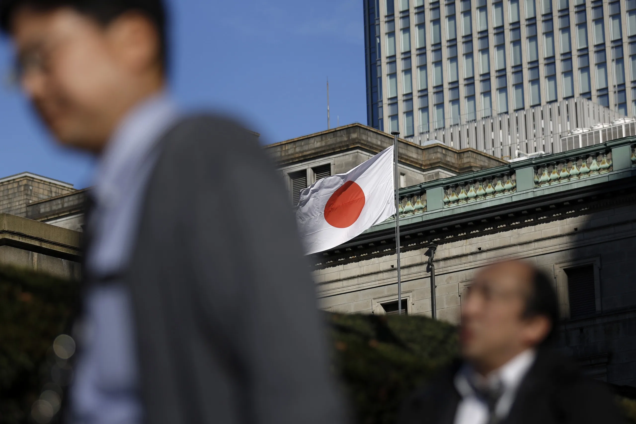 The Japanese national flag flies outside the Bank of Japan headquarters in Tokyo, Japan.