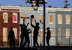 Young boys play basketball in a blighted neighborhood in Baltimore.
