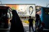 Pedestrians pass in front of political mural depicting Ruhollah Khomeini, founder of the Islamic republic of Iran, in Tehran, Iran, on Saturday, May 18, 2019. President Donald Trump warned Iran not to threaten the U.S. or face ruinous consequences as tensions mount between Washington and Tehran.
