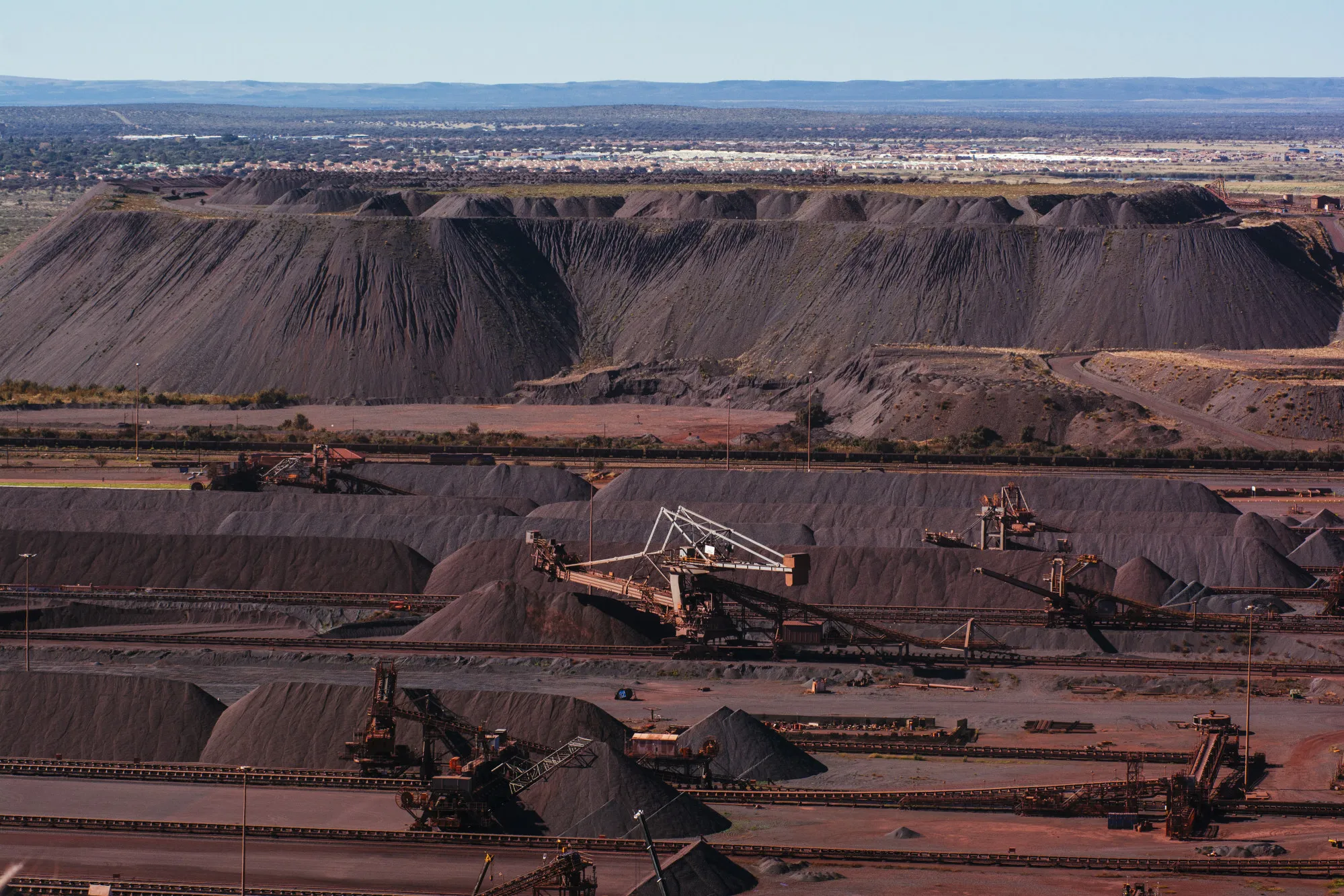 Stackers drop iron ore into stockpiles at an Anglo American Plc mine&nbsp;in Sishen, South Africa.