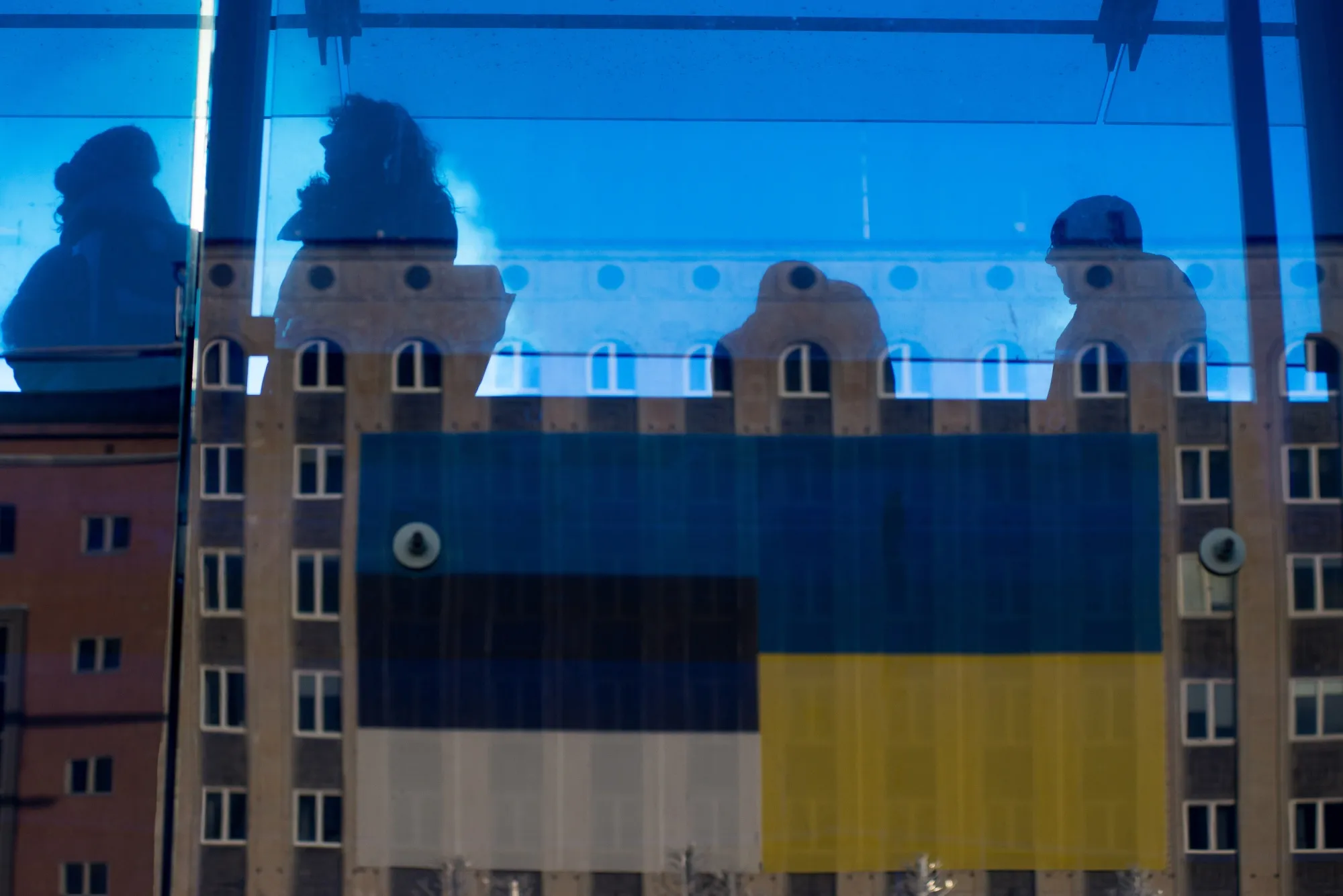 The flags of Ukraine, right, and Estonia reflected in a bus stop on Freedom Square in Tallinn.