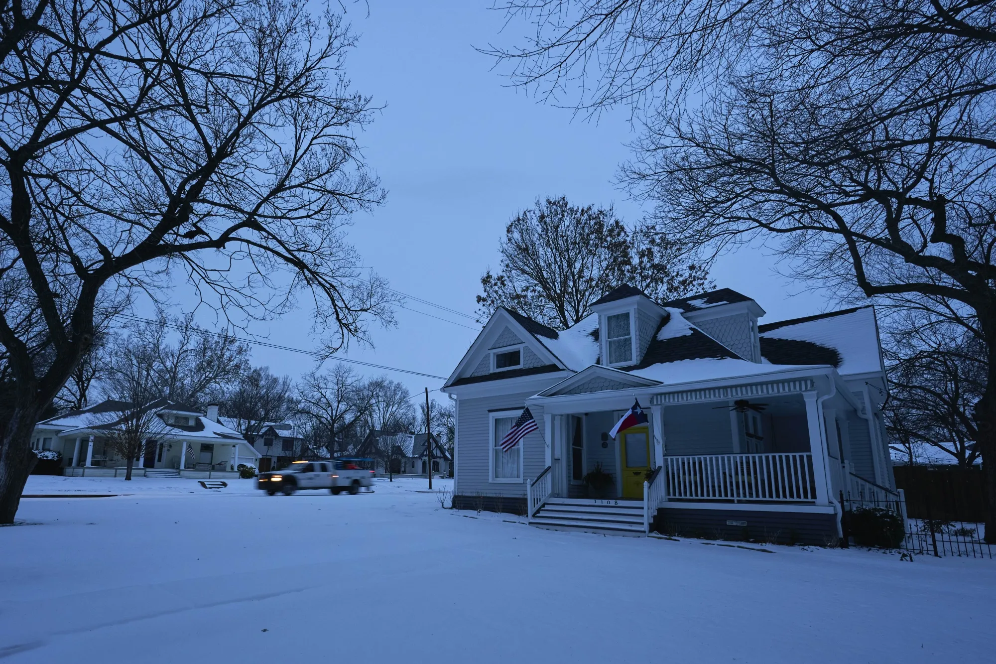 A utilities truck drives down the street during a power outage in McKinney, Texas, Feb. 16, 2021.