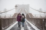 雪の中、ブルックリン橋を渡る人