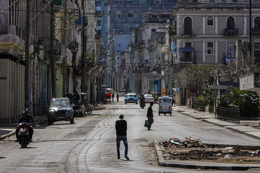 TOPSHOT - People walk along a quiet street in Havana on February 8, 2026. The Cuban government on February 6 announced emergency measures to address a crippling energy crisis worsened by US sanctions, including the adoption of a four-day work week for state-owned companies and fuel sale restrictions. (Photo by ADALBERTO ROQUE / AFP via Getty Images) Photographer: ADALBERTO ROQUE/AFP