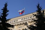 A Russian national flag flies above the headquarters of Bank Rossii, Russia's central bank, in Moscow.