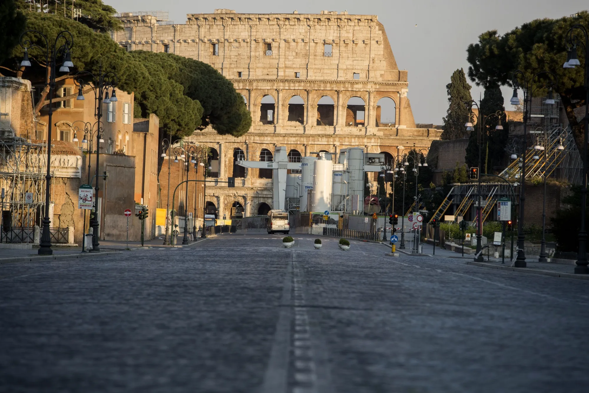 An empty street leads to the Colosseum in Rome.