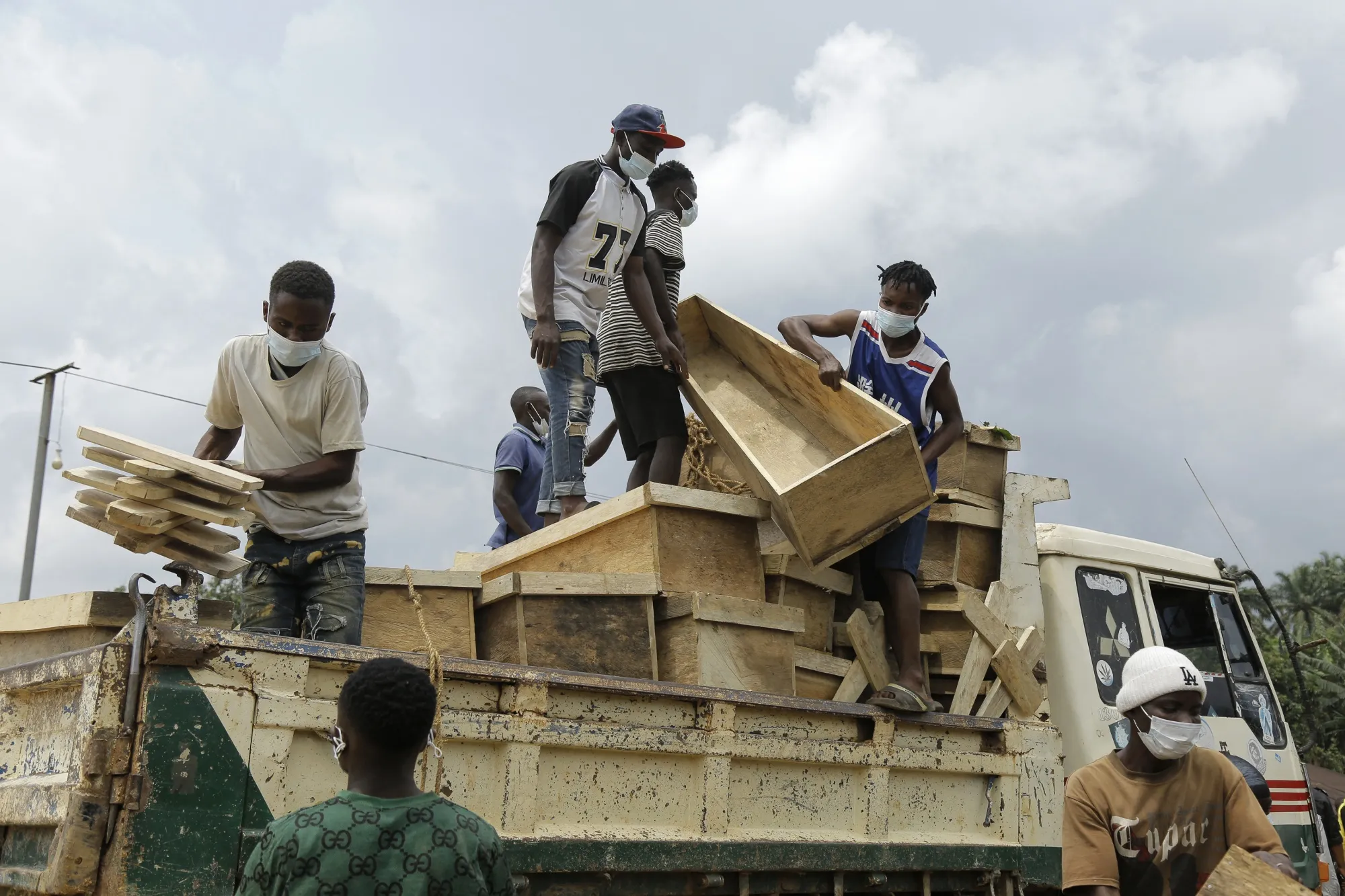 Volunteers offload freshly built coffins for victims of a recent attack in Ntoyo, Democratic Republic of Congo, on Sept. 10.