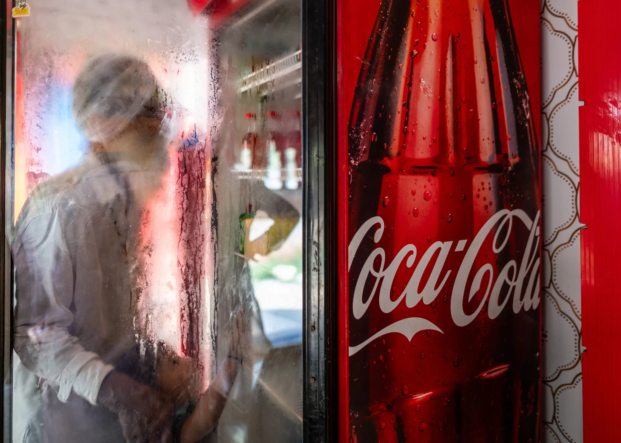 A child accompanied by an elder picks a soft drink of his choice inside a shop in Sirsiwala village, Punjab, India, on Aug. 8, 2023.