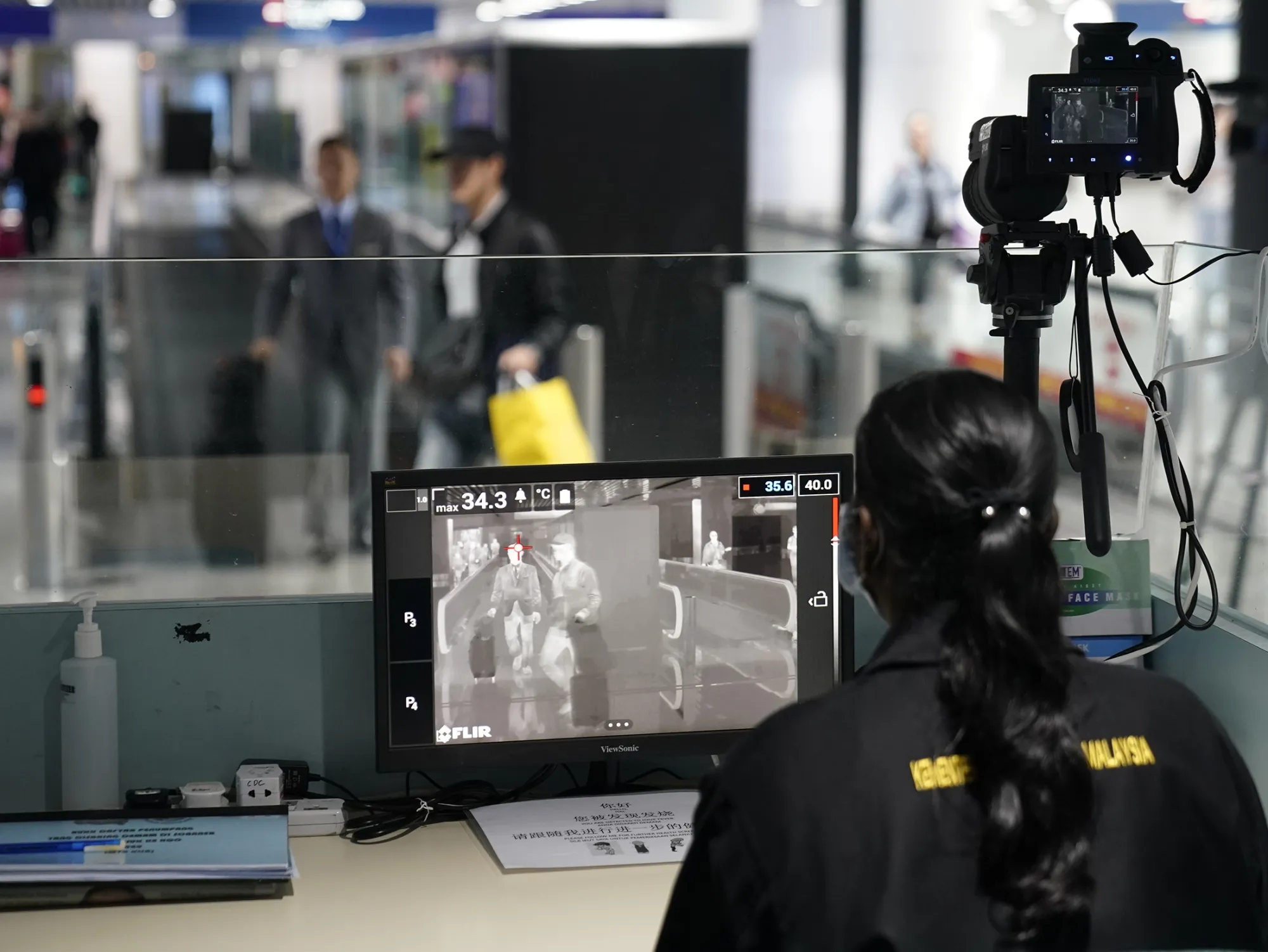 Health officials watch thermographic monitors at a quarantine inspection station at the Kuala Lumpur International Airport in Sepang.