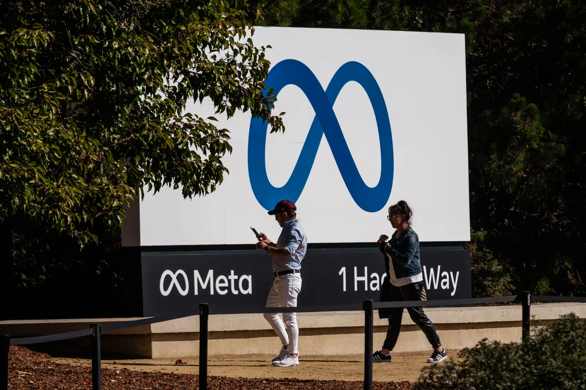Visitors take photographs in front of signage at Meta Platforms headquarters in Menlo Park, California.