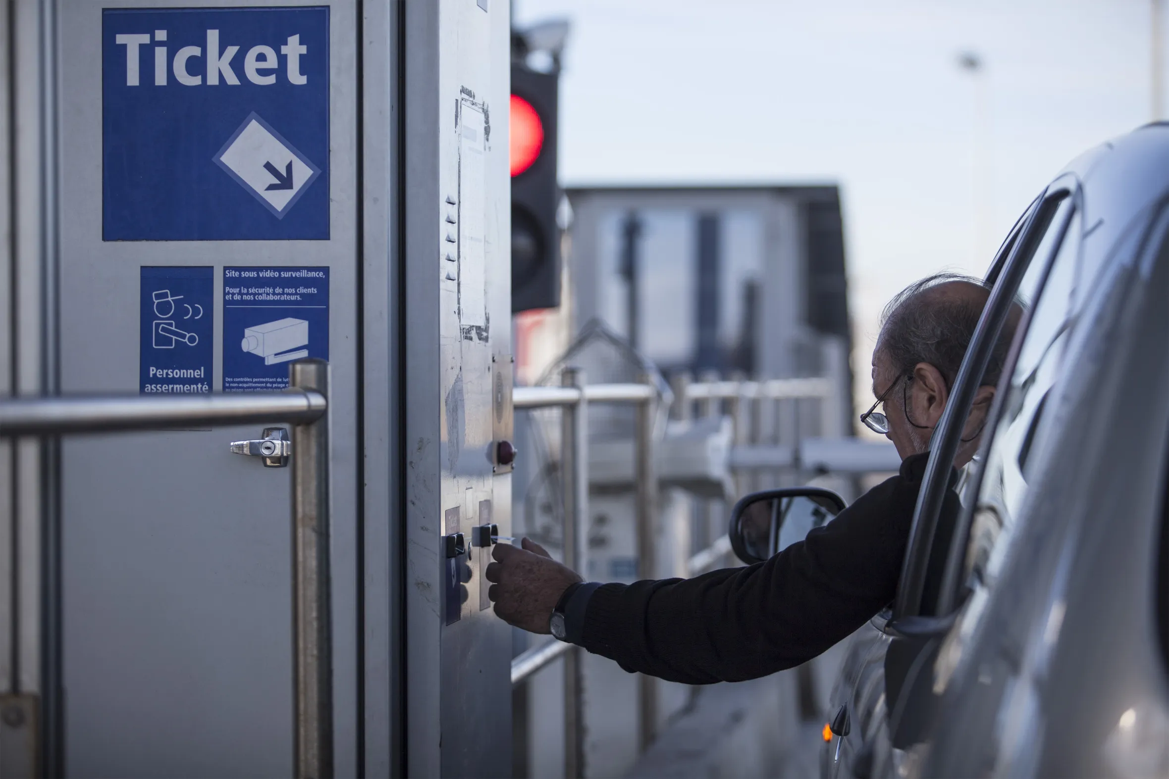 A motorist collects a ticket at the toll booth as they enter a motorway in Toulouse, France.