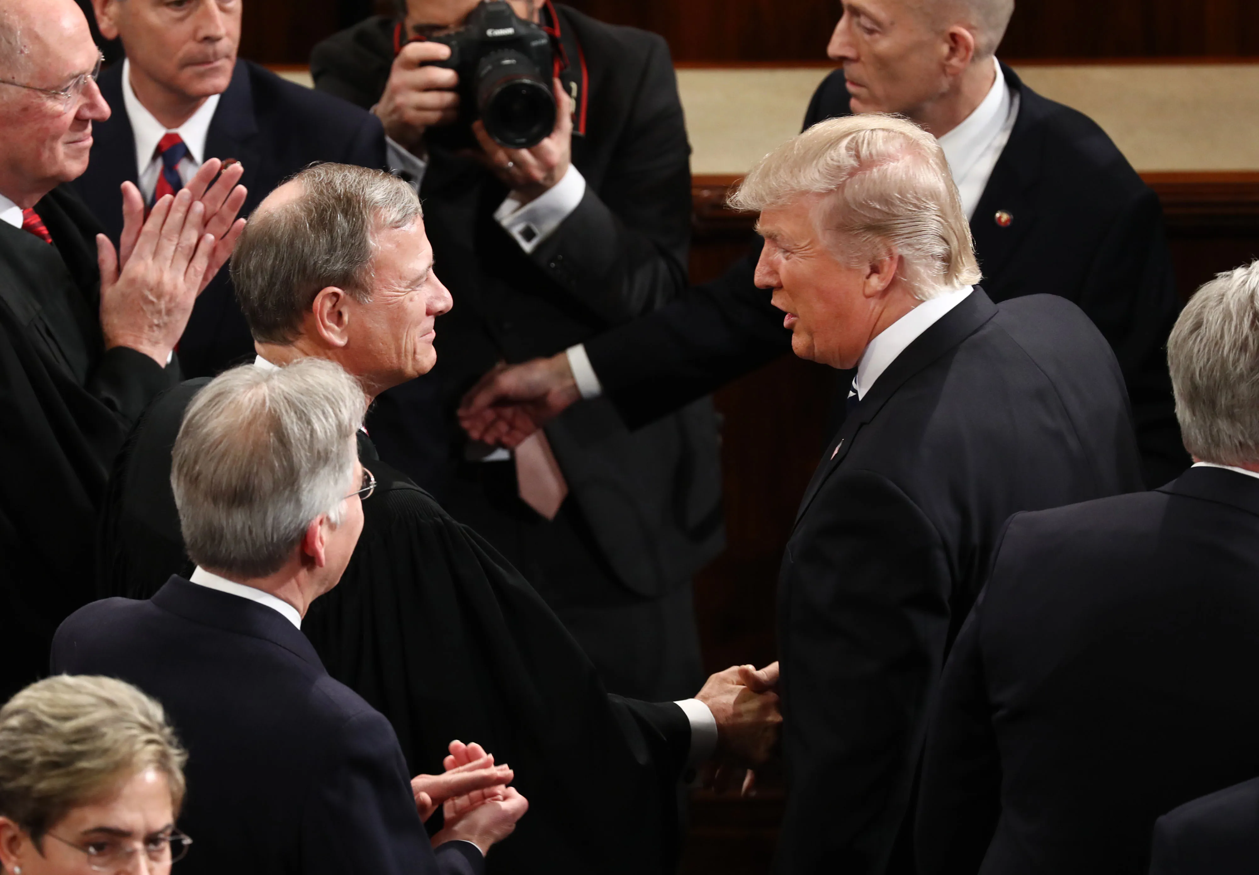
President Donald Trump, right, shakes hands with Supreme Court Chief Justice John Roberts.
