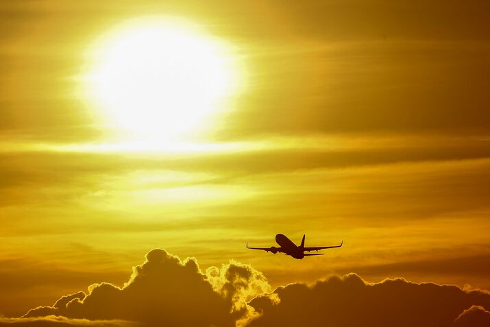A passenger aircraft flies at sunset