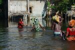 Villagers in West Bengal wade through flood waters on Aug. 23.
