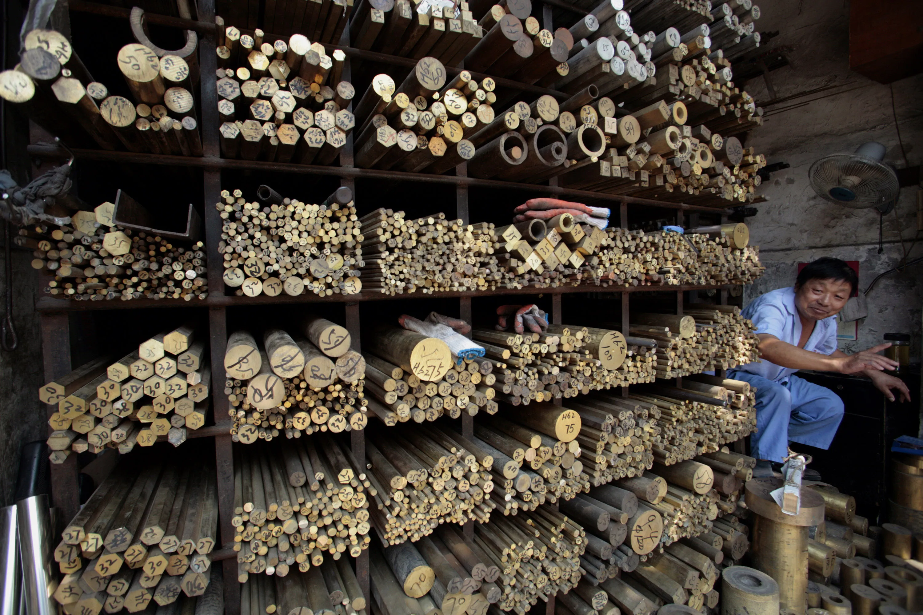 A vendor sits at a copper rod retail shop in Shanghai.

