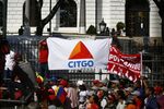 A pro-government supporter holds a banner displaying the logo of Citgo Petroleum, the U.S. refiner controlled by Petroleos de Venezuela SA (PDVSA)
