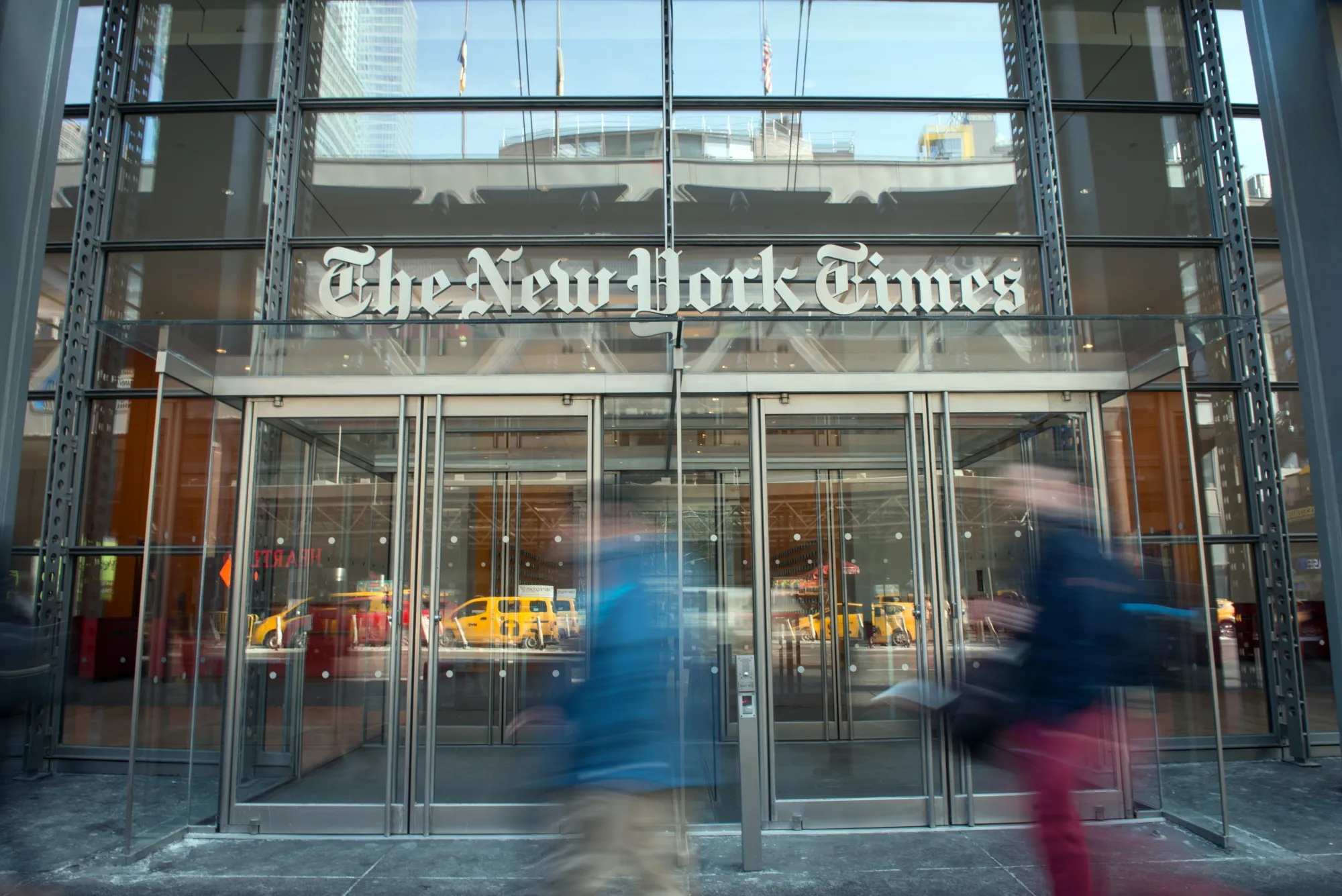 Pedestrians pass in front of the New York Times headquarters.