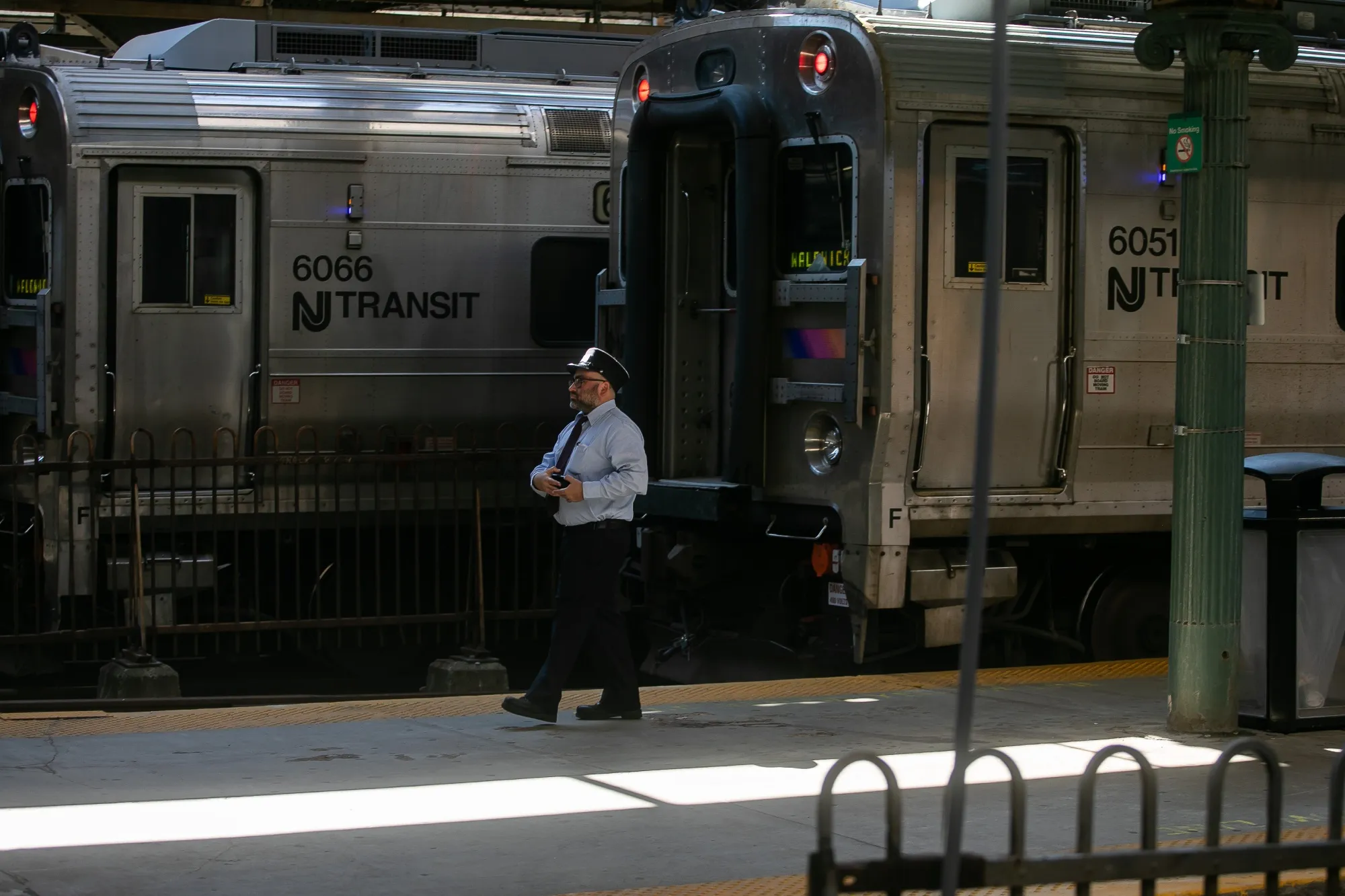 A conductor next to a New Jersey Transit train at the Hoboken Terminal in Hoboken, New Jersey, US, on Thursday, Oct. 19, 2023. 