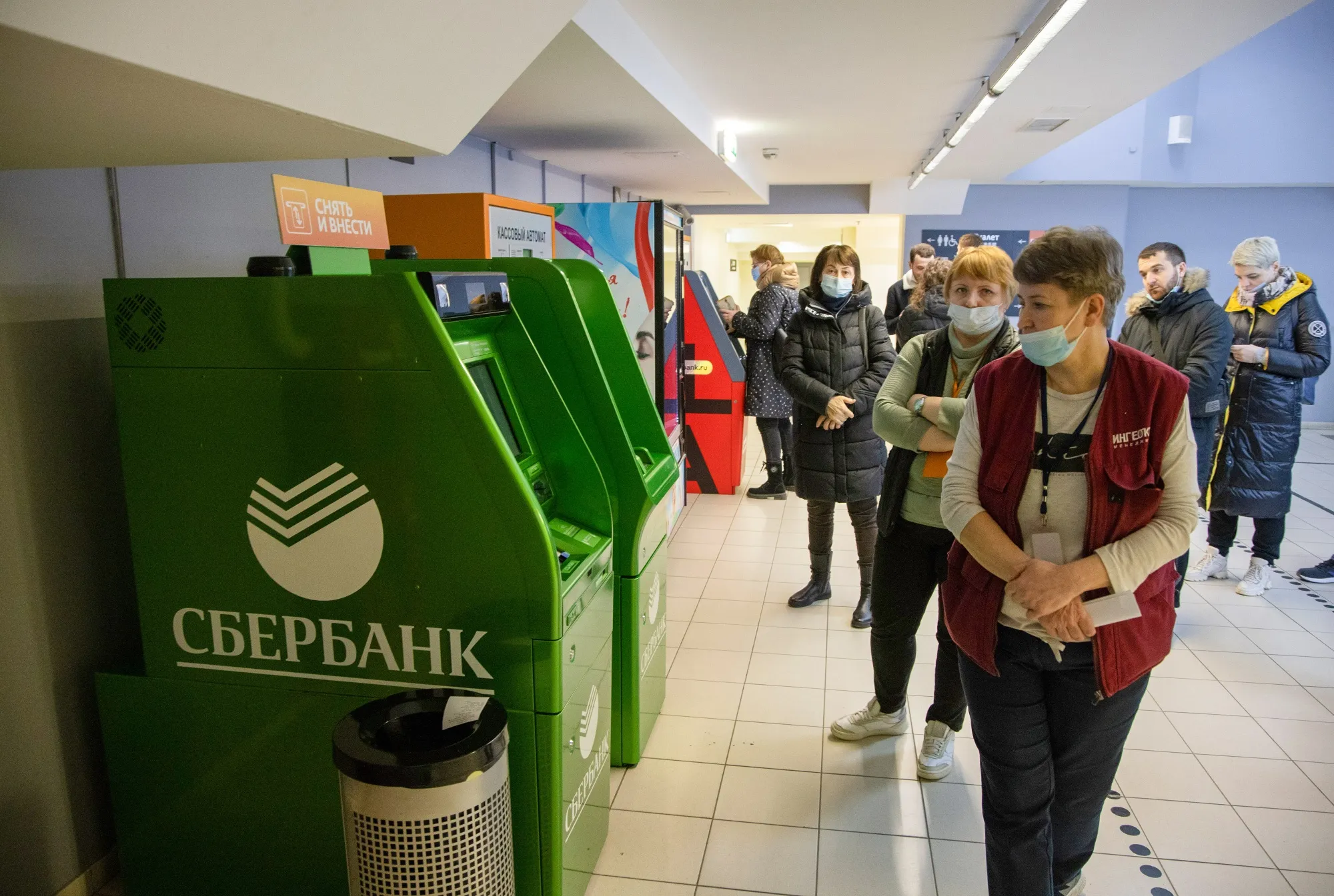 Customers queue to use a Sberbank ATM inside a shopping mall in Moscow, on&nbsp;Feb. 24.