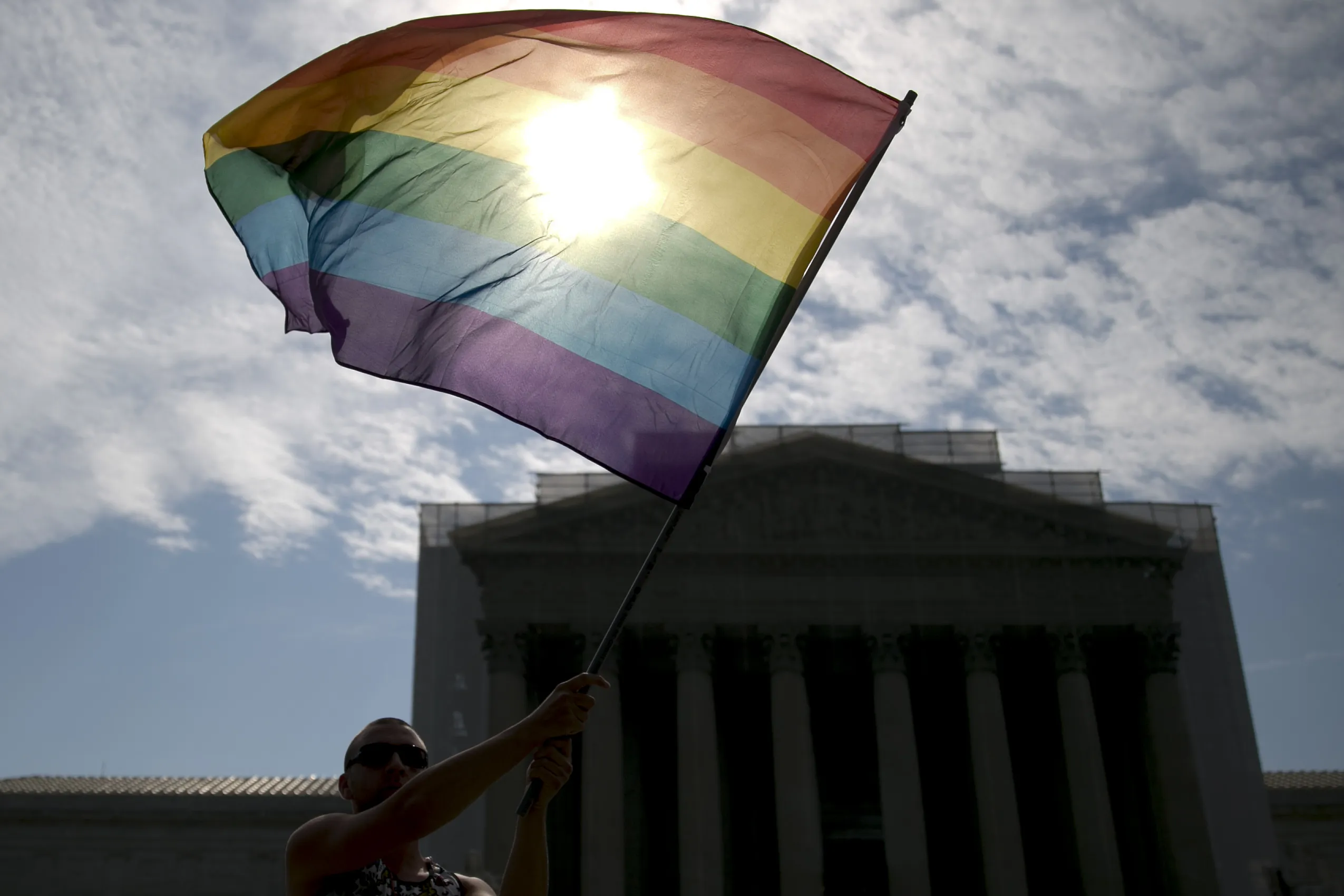 A rainbow colored flag is waived outside the U.S. Supreme Court.