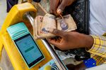 A mobile point of sale operator counts out Nigerian naira banknotes&nbsp;in Lagos, Nigeria.