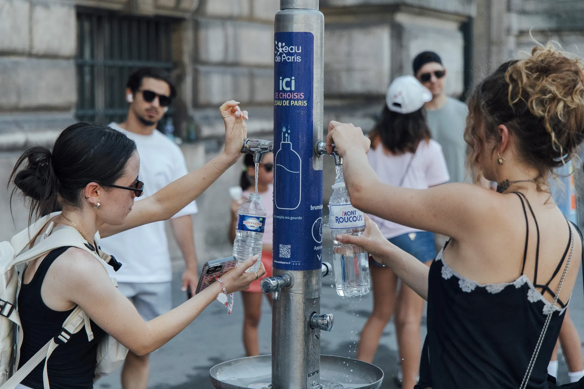 Visitors fill water bottles near the Louvre during hot weather in Paris, on July 1.