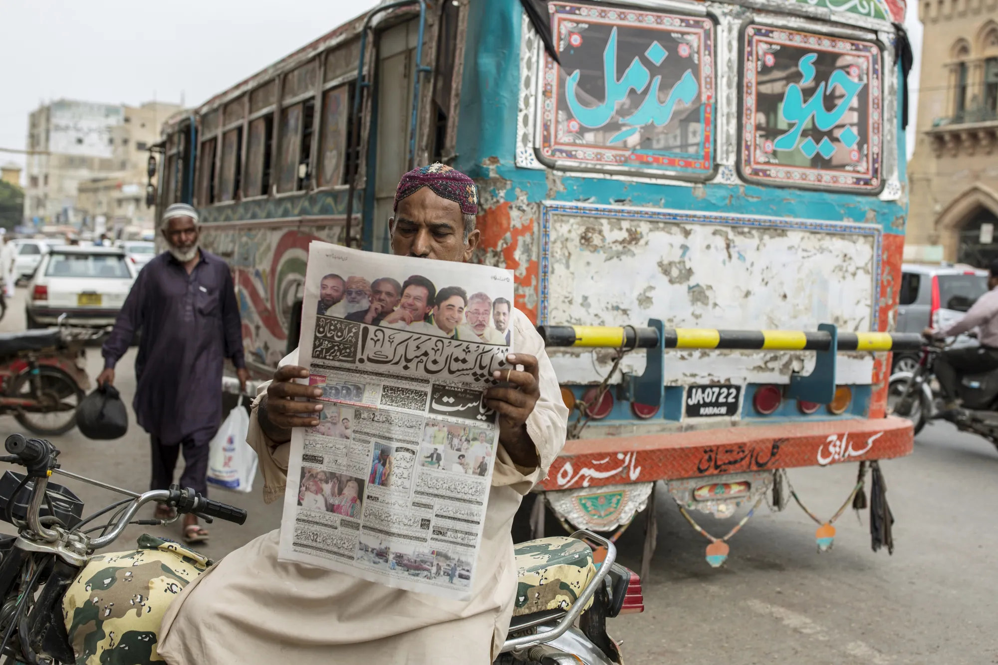 A man reads a newspaper reporting Pakistan's election results in Karachi, on July 26.