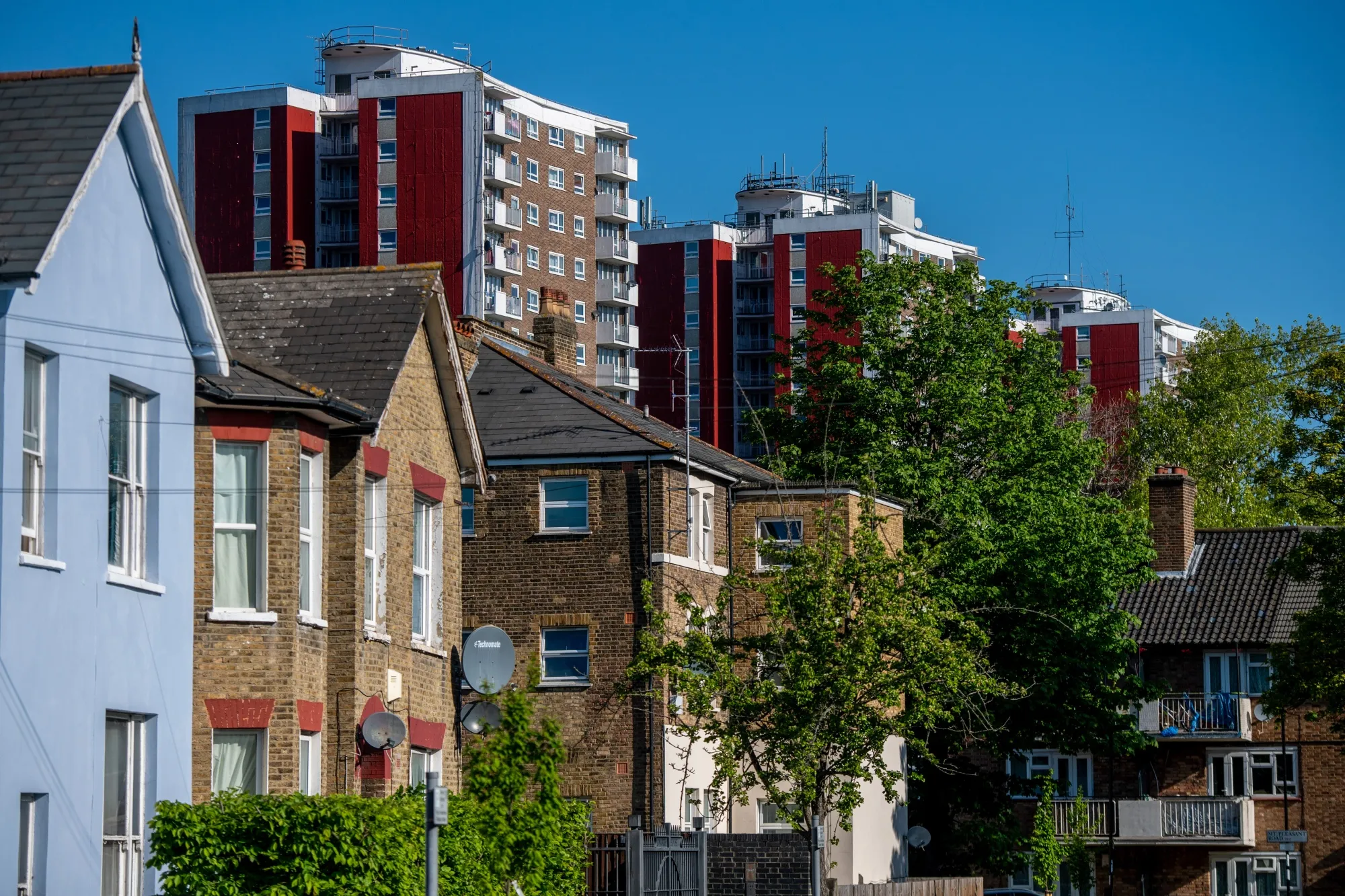 Residential houses stand in view of blocks of flats in London.