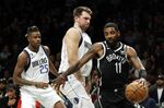 Kyrie Irving dribbles arouund&nbsp;Luka Doncic of the Dallas Mavericks.