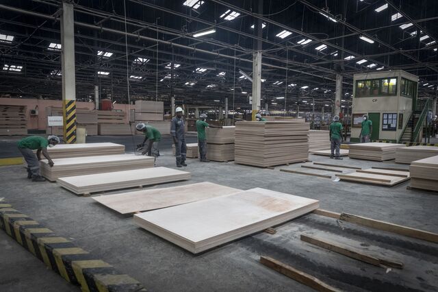 Men work at a timber processing plant managed by African Equatorial Hardwoods (AEH) in Port-Gentil on October 14, 2022.