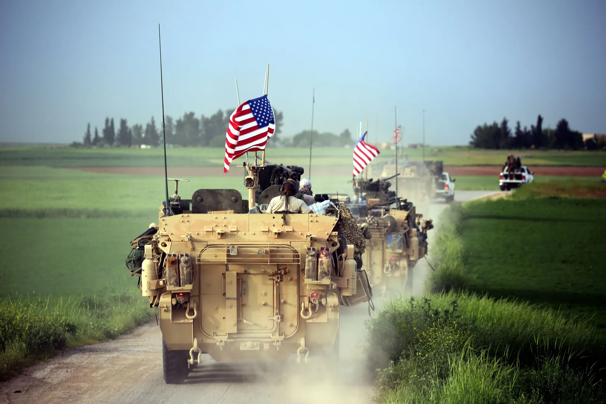 TOPSHOT - US forces, accompanied by Kurdish People's Protection Units (YPG) fighters, drive their armoured vehicles near the northern Syrian village of Darbasiyah, on the border with Turkey on April 28, 2017. / AFP PHOTO / DELIL SOULEIMAN        (Photo credit should read DELIL SOULEIMAN/AFP/Getty Images)