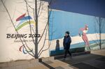 A pedestrian passes a hoarding set up for the Beijing 2022 Winter Olympic and Paralympic Games at Shougang Park in Beijing, China, on Thursday, Jan. 13, 2022. 