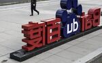A man walks past a sign for Baidu Inc. at the entrance to the Baidu Technology Park in Beijing.