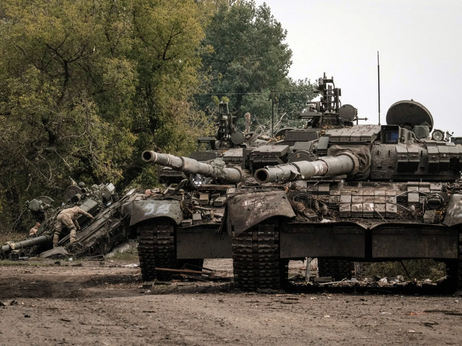 Ukrainian soldiers (L) scavenge an abandoned Russian T-90A tank in Kyrylivka, in the recently retaken area near Kharkiv, on September 30, 2022.

&nbsp;