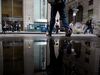 Pedestrians pass in front of a Charles Schwab Corp. branch on Wall Street near the New York Stock Exchange.