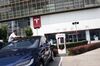 A man cleans a Tesla Inc. Model X electric vehicle connected to a charging station outside one of the company's showrooms in Beijing, China.