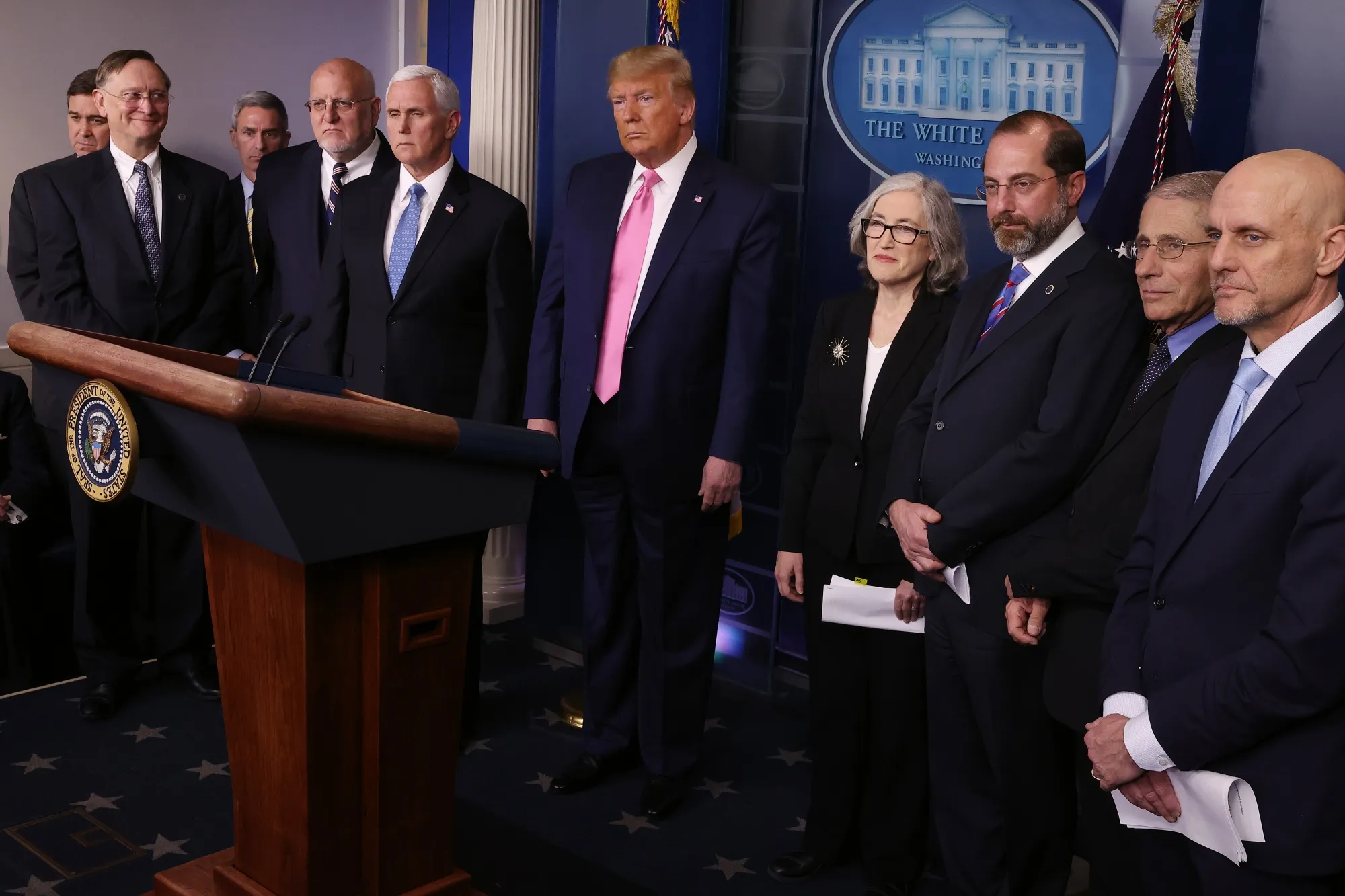 President Donald Trump stands with members of his coronavirus task force.