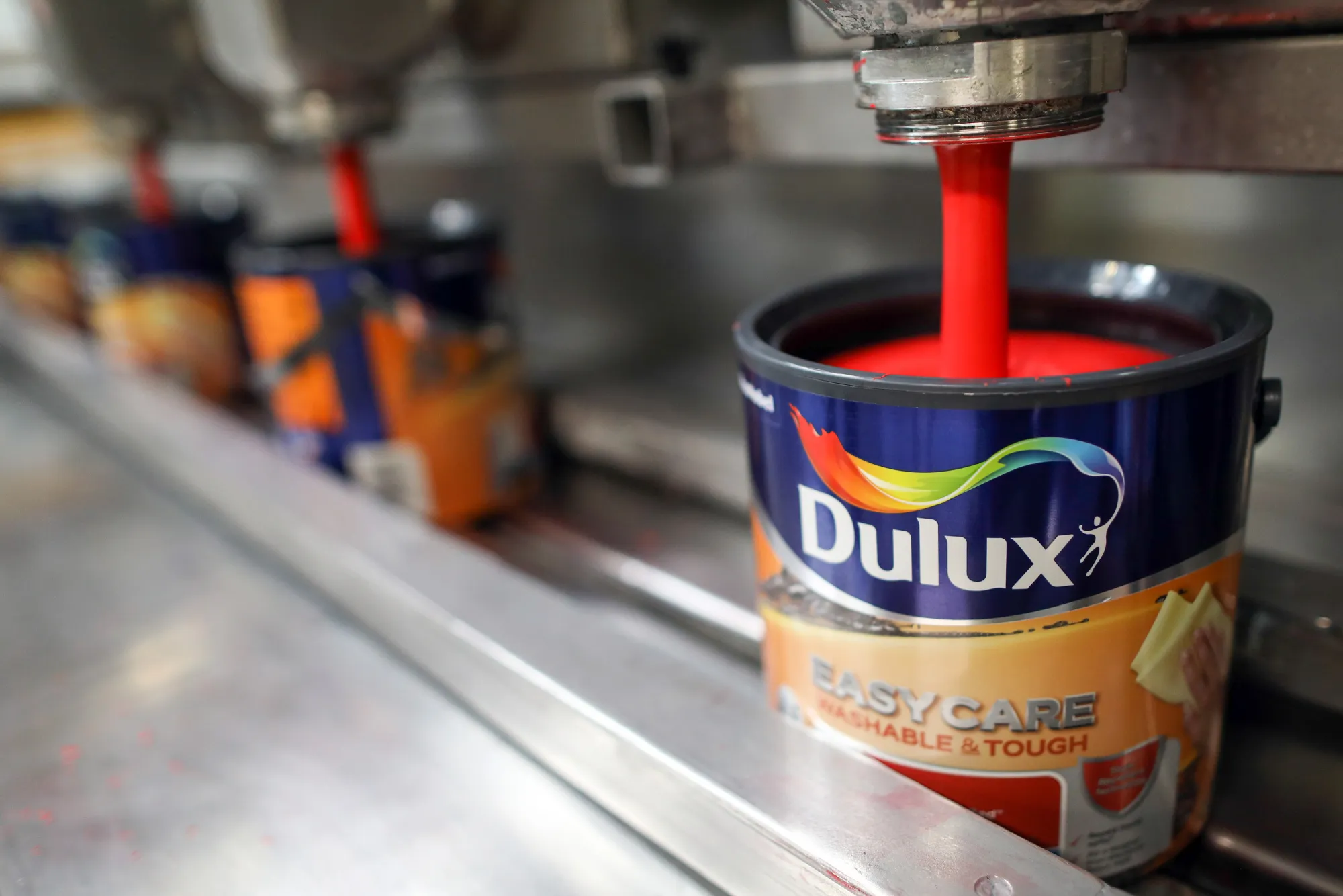 Dulux paint pours into a pot on the production line at Akzo Nobel NV's paint factory in Ashington, UK.