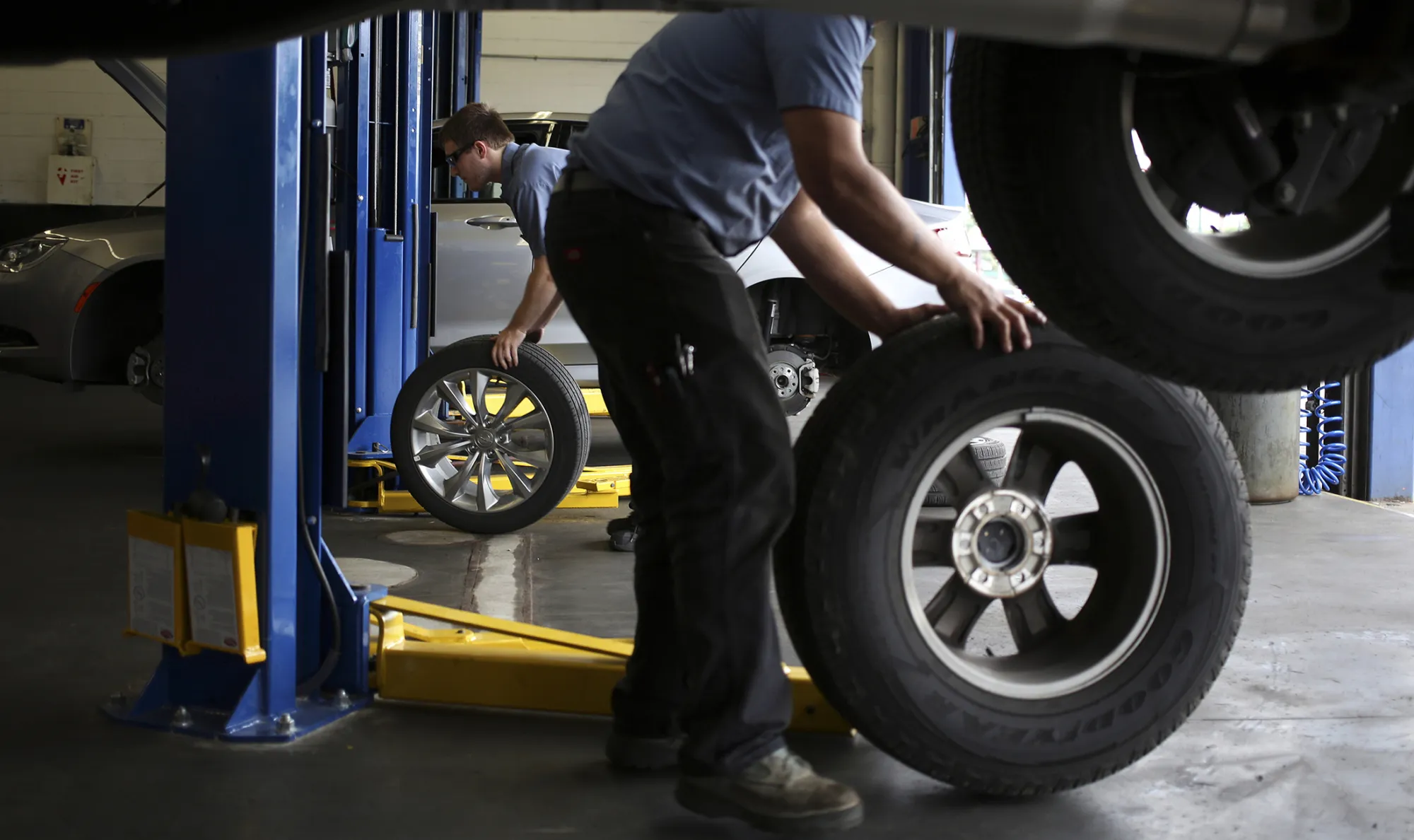 Service technicians perform tire rotrations on customer vehicles at a Pep Boys Company auto repair and service center in Clarksville, Indiana
