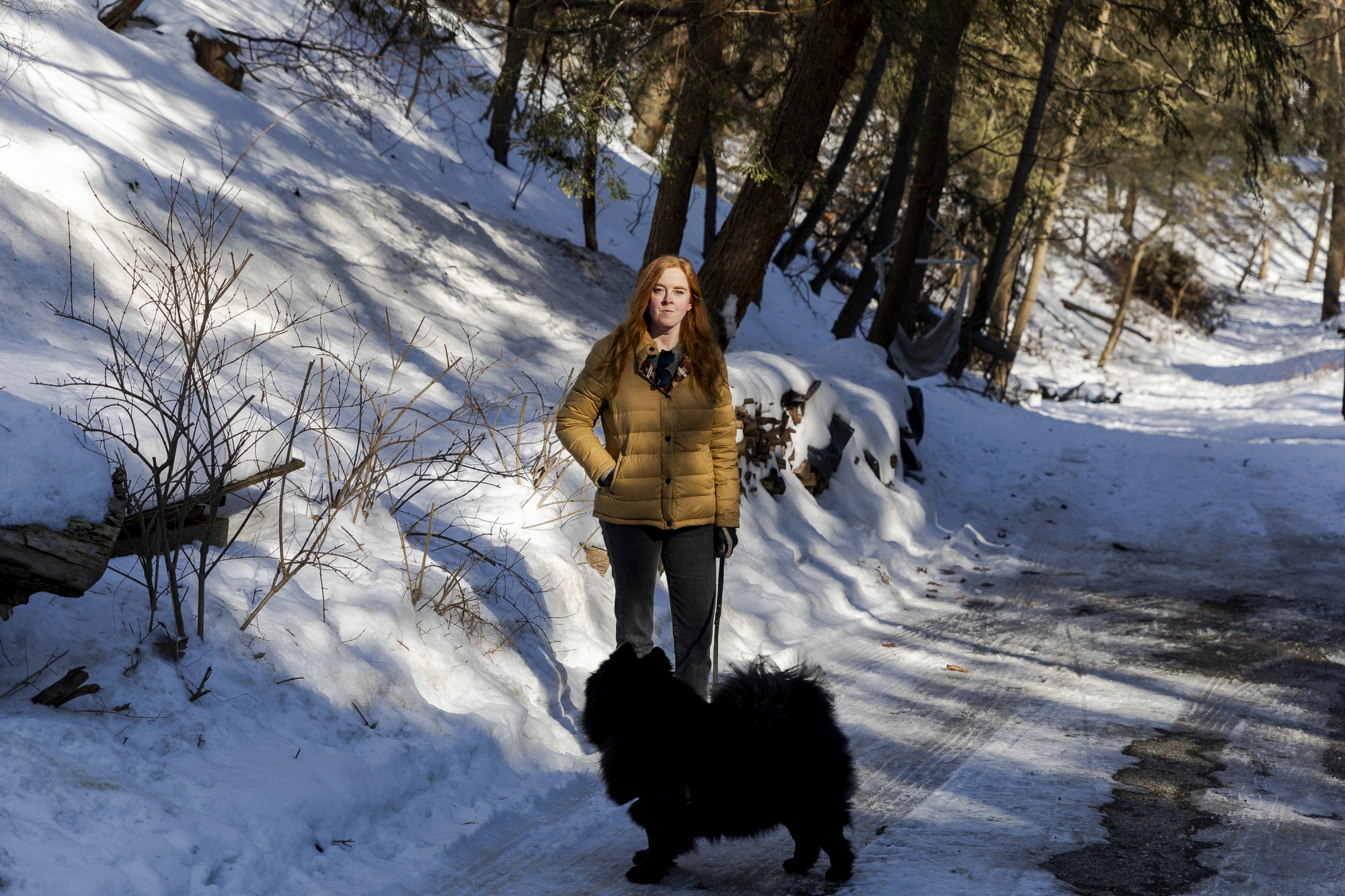 Elisabeth Mims, and her dog, Frank, outside of her home near the plant. Photographer: Sylvia Jarrus/Bloomberg