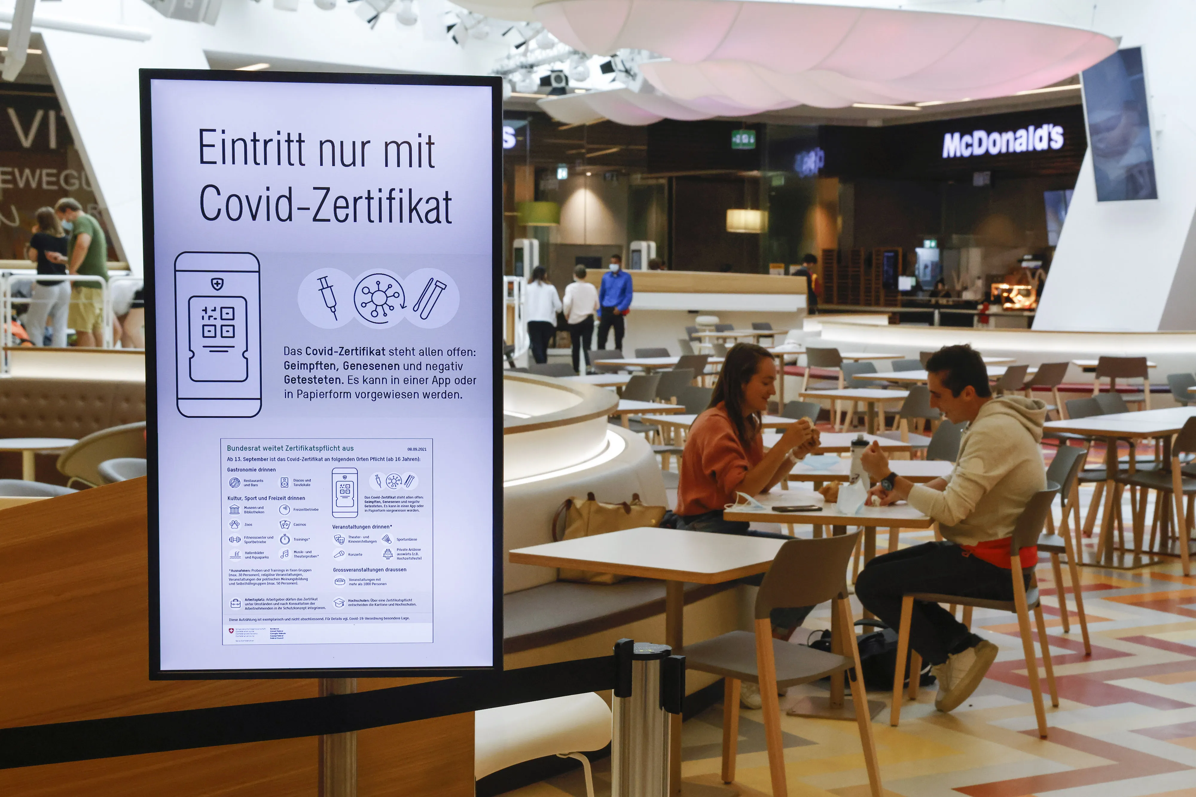 A sign for the Covid-19 certificate in a dining area in a shopping mall in Bern, Switzerland.