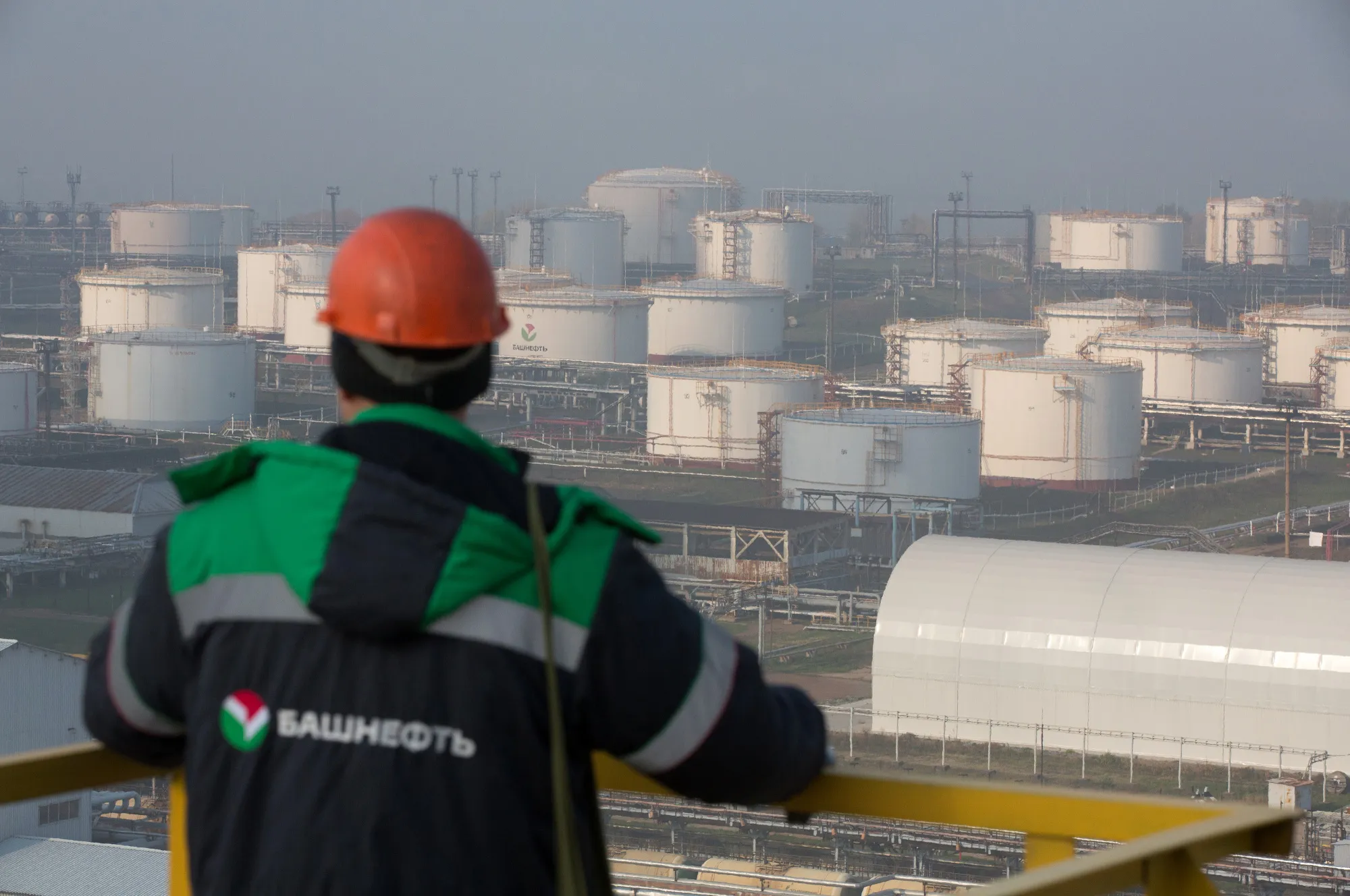 An employee looks across the oil and fuel storage facility at the Bashneft-Ufaneftekhim oil refinery&nbsp;in Russia.